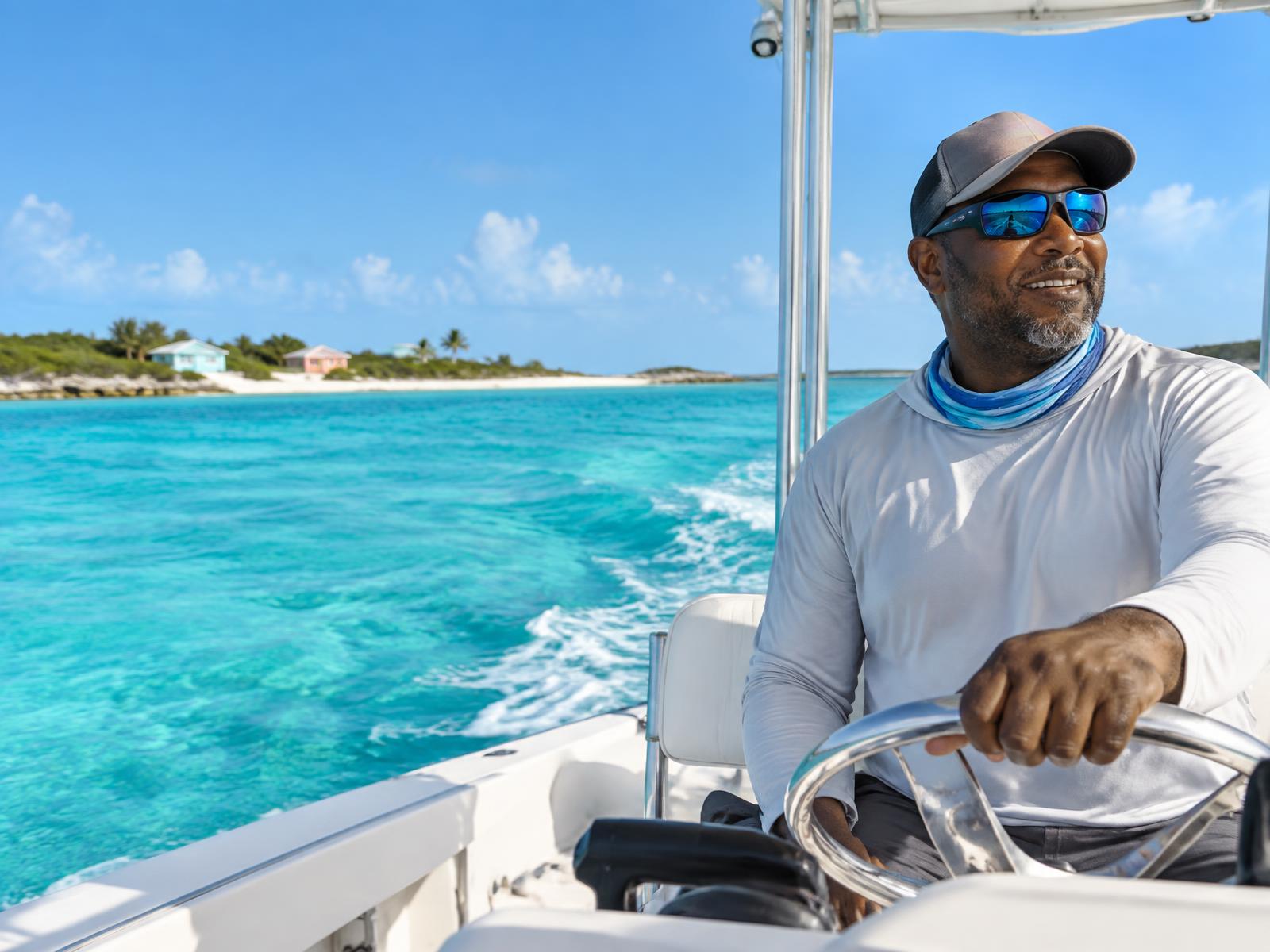A Bahamian captain at the wheel in the Exuma cays